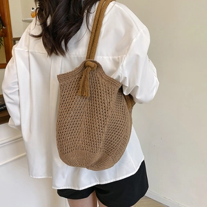 Caramel brown hollow knit shoulder bag with tassel detail shown on a model for summer