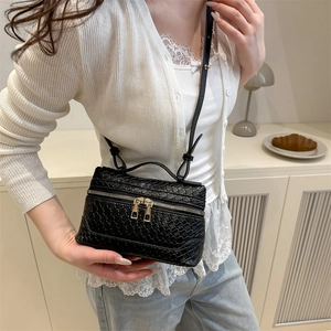 Elegant black woven box vanity bag with gold hardware and a detachable shoulder strap