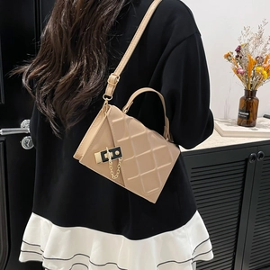 Elegant beige quilted leather crossbody bag with black metal lock and gold chain strap