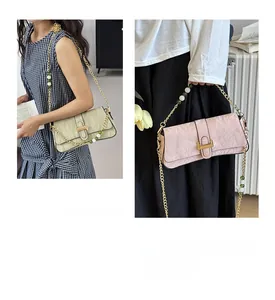 Detail view of stylish rectangle baguette bag featuring unique pleated leather and gold buckle