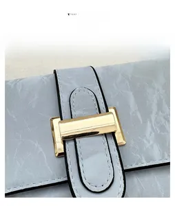 Close-up of marble texture leather bag with gold rectangular buckle and black edge detail
