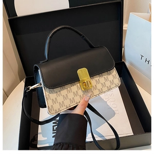 Detail view of the black and white monogram crossbody bag with gold lock and luxury styling