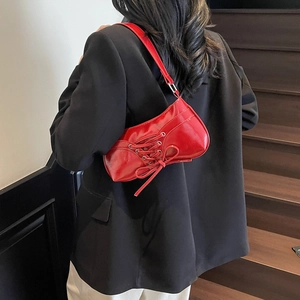 Sac à bandoulière rouge vintage avec dentelle et nœud, porté par un mannequin en escalier
