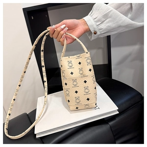 Detail of beige phone bag featuring bear prints and a textured lychee pattern finish