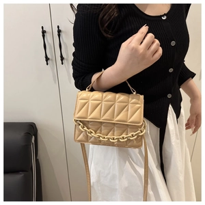 Detail of beige quilted faux leather crossbody bag featuring a stylish thick chain strap
