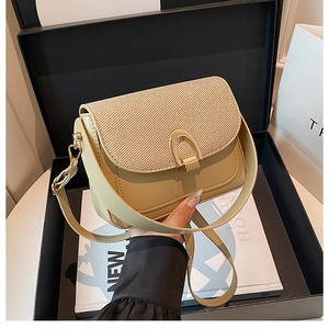 Détail du sac selle beige avec rabat en tissu texturé et fermoir en métal doré