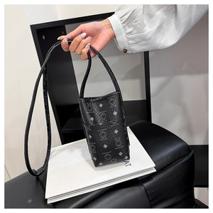 Detailed view of black mini crossbody phone bag with bear print and front pocket