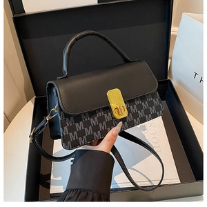 Detail of black crossbody bag with M-pattern print and golden rectangular twist lock
