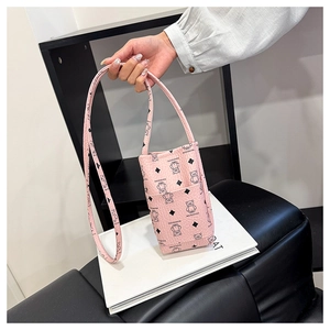 Detail of pink PU leather phone bag with black bear prints and textured front pocket