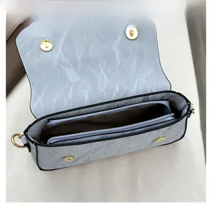 Detail view showing internal compartments and blue marble texture of the shoulder bag