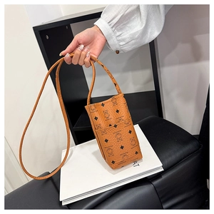 Close-up of litchi texture on brown crossbody phone bag with cartoon bear print