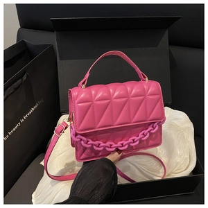 Close-up of rose red geometric quilted handbag with resin chain in premium gift box