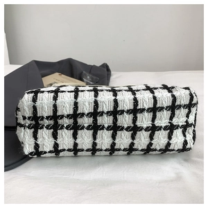 Macro view of black and white checkered tweed fabric texture and weave of the tote bag