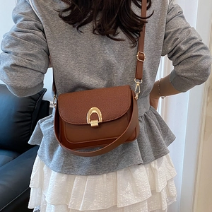 Sac bandoulière marron en cuir avec rabat tressé et boucle fer à cheval dorée
