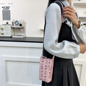 Pink crossbody phone bag with cartoon bear print and textured leather on a female model