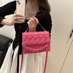 Magenta quilted crossbody bag with chunky chain detail and shoulder strap for women