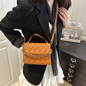 Minimalist bright orange quilted square handbag with chunky chain detail and thin strap