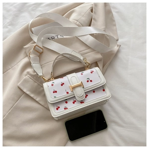 Detailed view of cherry print shoulder bag with a phone for size reference