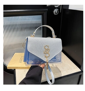 Détail du sac en PVC bleu matelassé avec rabat pailleté et logo SS en métal doré