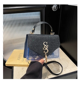 Détail du sac bleu en PVC matelassé avec rabat pailleté et breloque dorée à pompon