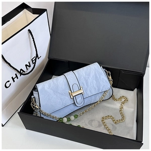 Detail of light blue wrinkled faux leather shoulder bag with a gold buckle in a gift box