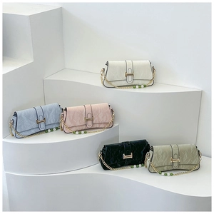 Detailed display of colorful pleated leather shoulder bags with gold chains and beaded charms