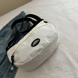 Detail of white half-moon crossbody bag with LUCKY FASHION logo on nylon crinkle fabric