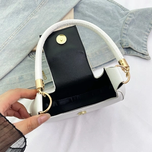 Macro detail of white crossgrain leather bag interior with gold ring clasp and magnet