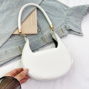 Detail of white cross-grain leather shoulder bag with gold hardware on denim background