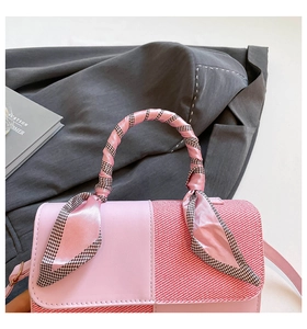 Detail of pink leather handbag with plaid panels and houndstooth silk scarf handle wrap