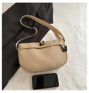 Detailansicht der beigen Canvas-Tasche mit verstellbarem Gurt und Doppelreißverschluss