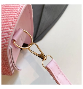 Detail of pink leather handbag showing gold metal buckle and tweed fabric texture