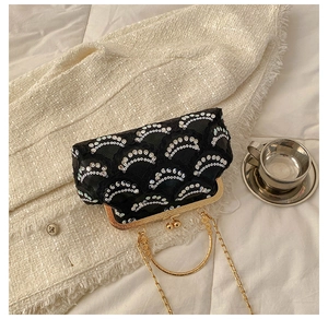 Detailed view of vintage black sequin evening bag with gold kiss-lock and metal handle