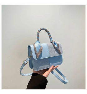 Close-up of light blue patchwork handbag with silk scarf handle and adjustable strap