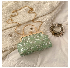 Detailed shot of mint green sequin clutch bag with vintage gold metal frame and chain