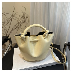 Détail du sac seau crème montrant la poignée tressée et le logo gaufré ENED & BAG