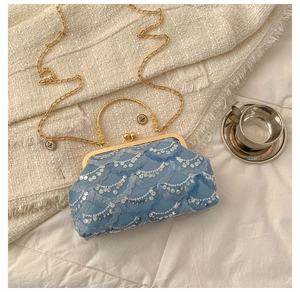 Blue lace clutch with water ripple sequins, gold metal frame, and top handle detail