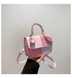 Detail of pink patchwork handbag with glossy leather, checkered fabric and silk scarf