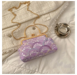 Detail of lavender sequined evening bag with golden metal frame and chain strap