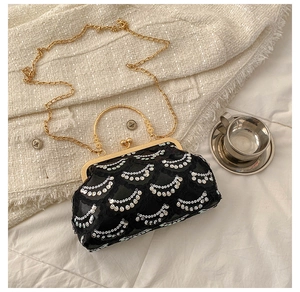 Detail of vintage evening bag featuring silver moon sequins and golden engraved handle