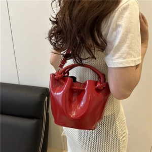 Sac seau en cuir verni rouge avec poignée nouée unique et bandoulière réglable pour femme