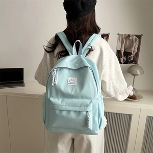 Minimalist light blue school backpack with smiley face patch and rope zipper details