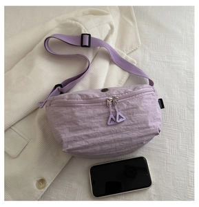 Détail du sac bandoulière en nylon violet avec fermeture éclair et téléphone de référence