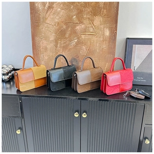 Detail of color-block handbags in yellow, black, brown and red with wrinkled leather texture