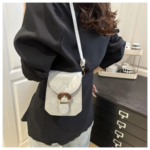 Petit sac bandoulière gris pour téléphone avec bouton en bois porté par un mannequin