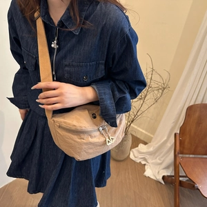 Détail du sac bandoulière demi-lune kaki avec double fermeture éclair et sangle en tissu