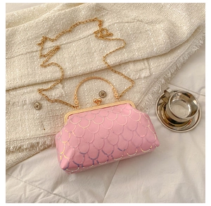 Detail view of pink sequin handbag with vintage gold buckle on tweed background