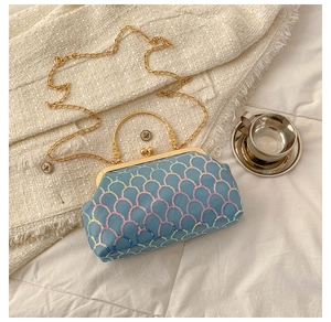 Detail of blue iridescent sequin handbag with gold metal handle and vintage clasp