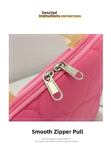 Close-up of dual silver metal zippers on pink quilted fabric for laptop storage bag