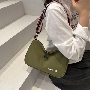 Dettaglio della borsa tote in tela verde oliva con tracolla a righe e logo FANYISSA